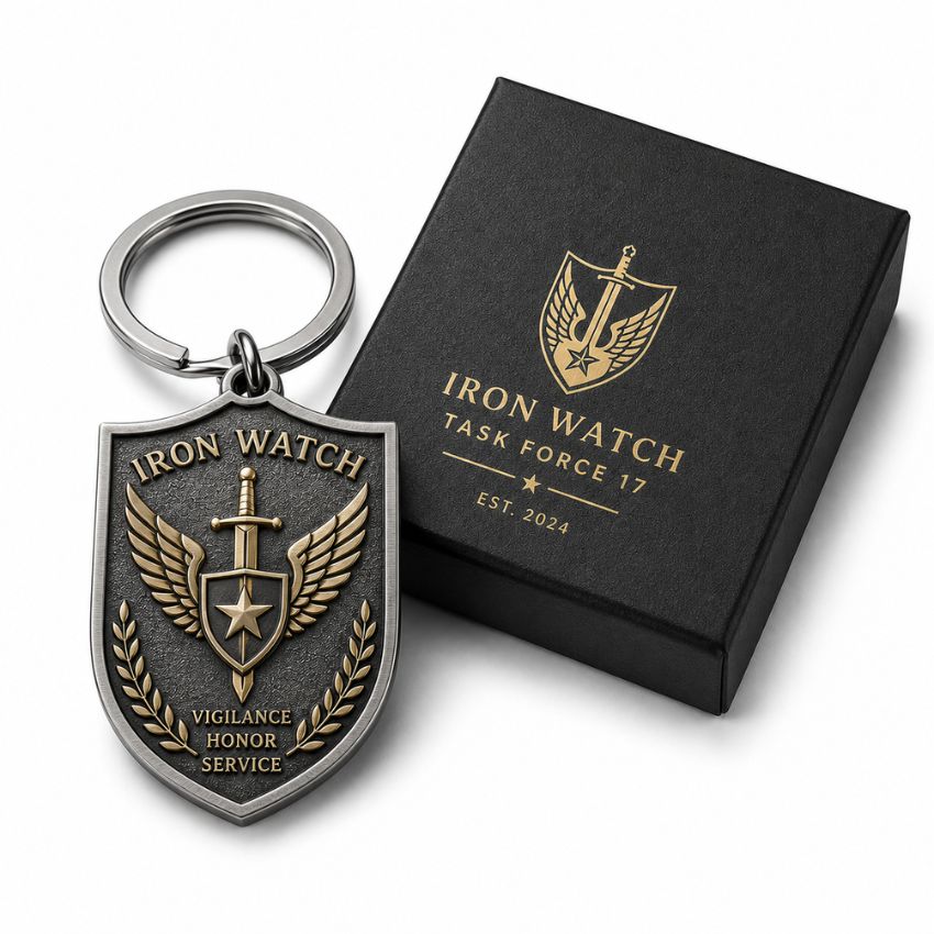 Custom shield-shaped Iron Watch task force metal keychain beside a black gift box with gold foil logo.
