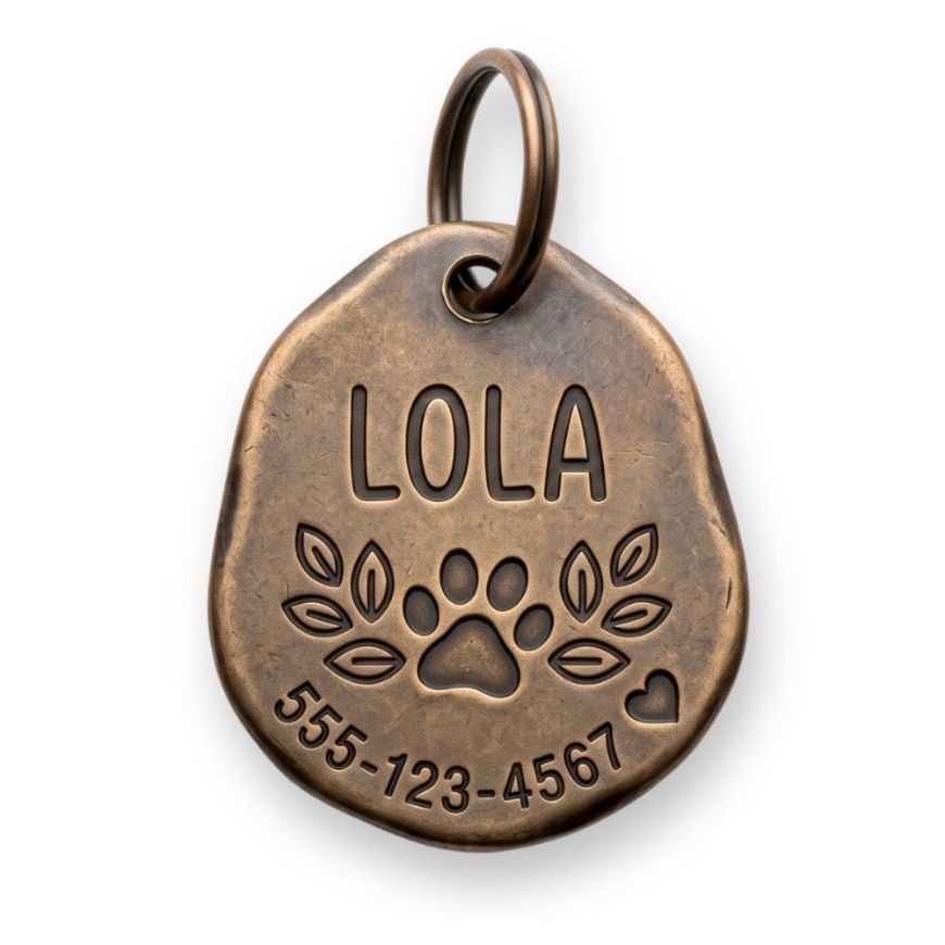 Irregular antique bronze pet ID tag with stamped leaves, paw emblem, and personalized phone number engraving.