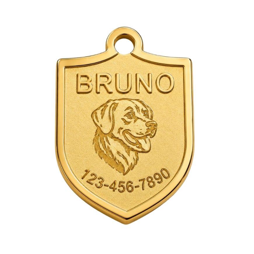 Gold shield-shaped pet ID tag with engraved dog portrait and owner contact number for custom pet merchandise.