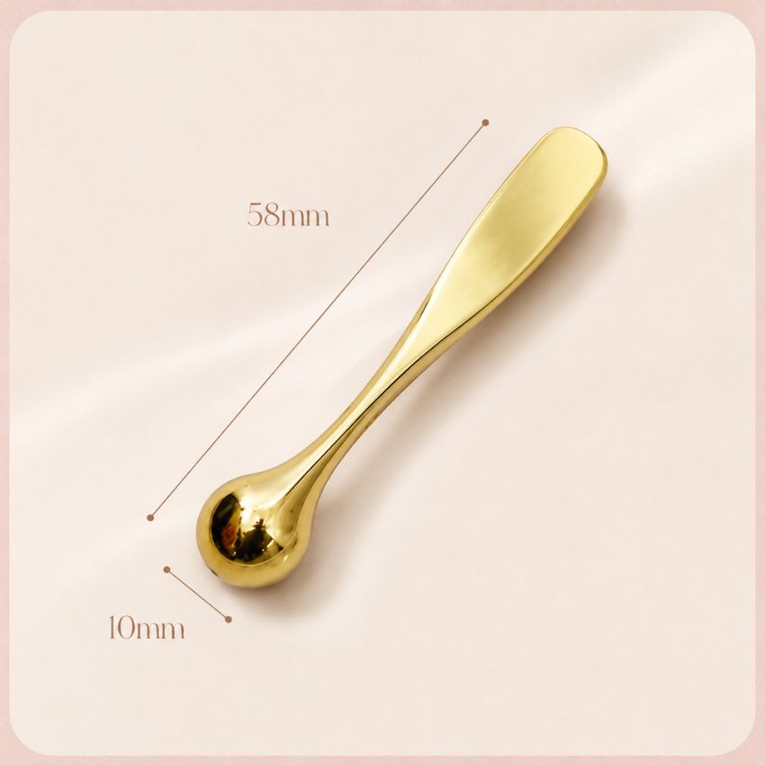 Compact gold metal eye cream applicator and massager, 58mm portable beauty skincare tool.
