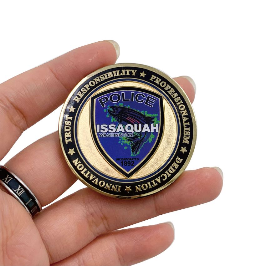 Demonstration of a premium metal corporate challenge coin with colorful enamel detailing.