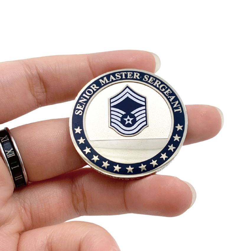 Person holding custom silver USAF Senior Master Sergeant rank award coin, showcasing realistic size and premium product.