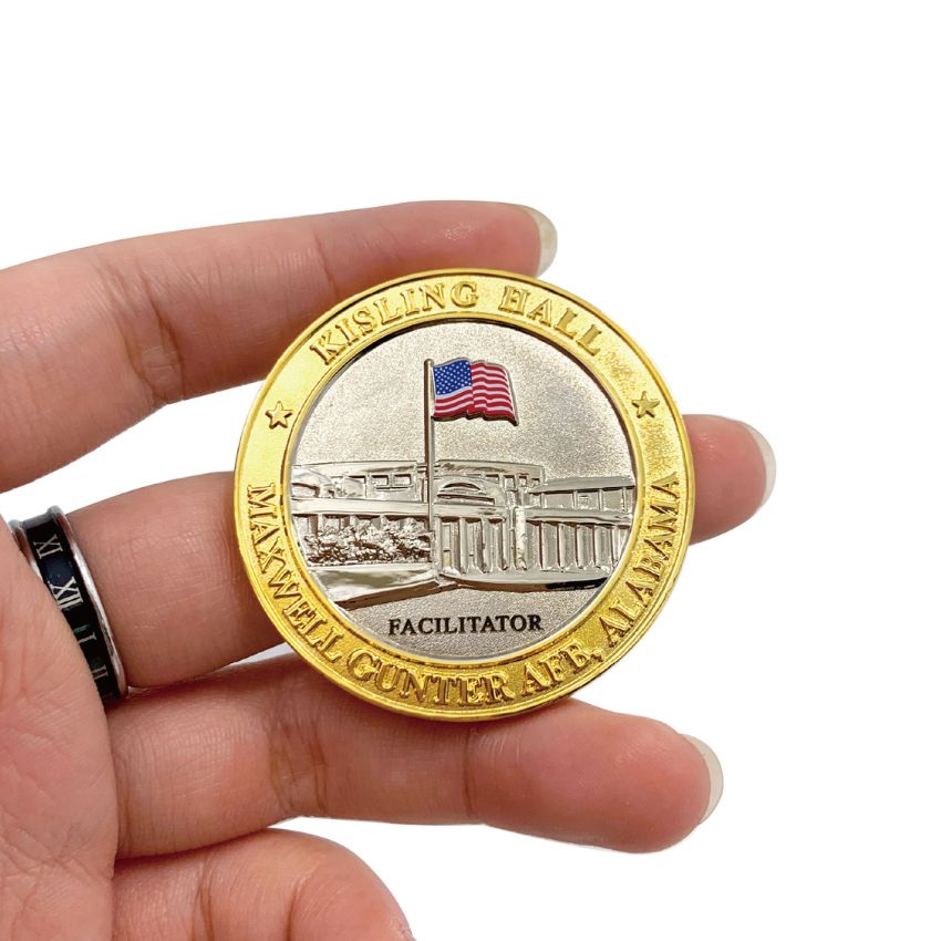 Custom Maxwell Gunter AFB facilitator gold coin held in hand, demonstrating the detailed 3D building and US flag engraving.