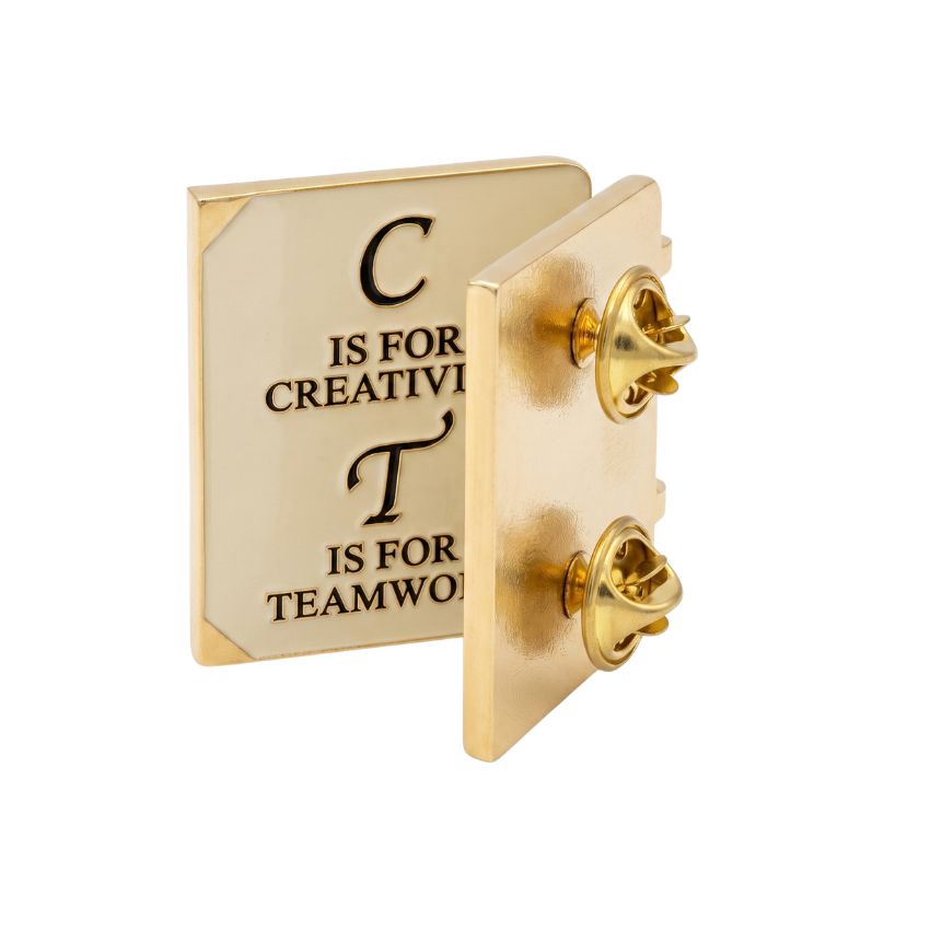 Back view of custom book-shaped hinged enamel lapel pin showing dual butterfly clutches and gold metal finish.