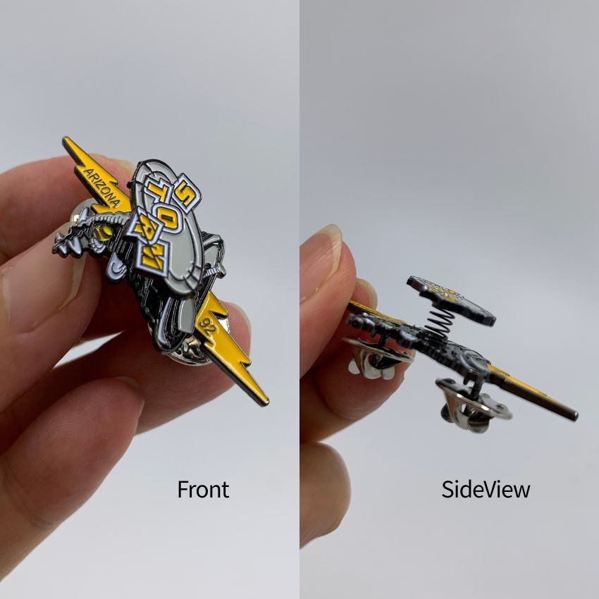 Hand holding front and side angles of a custom sports team bobble pin with spring mechanism for interactive promotional products.