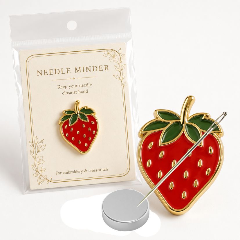 Custom strawberry enamel needle minder with branded backing card packaging and magnet, B2B craft supplies.
