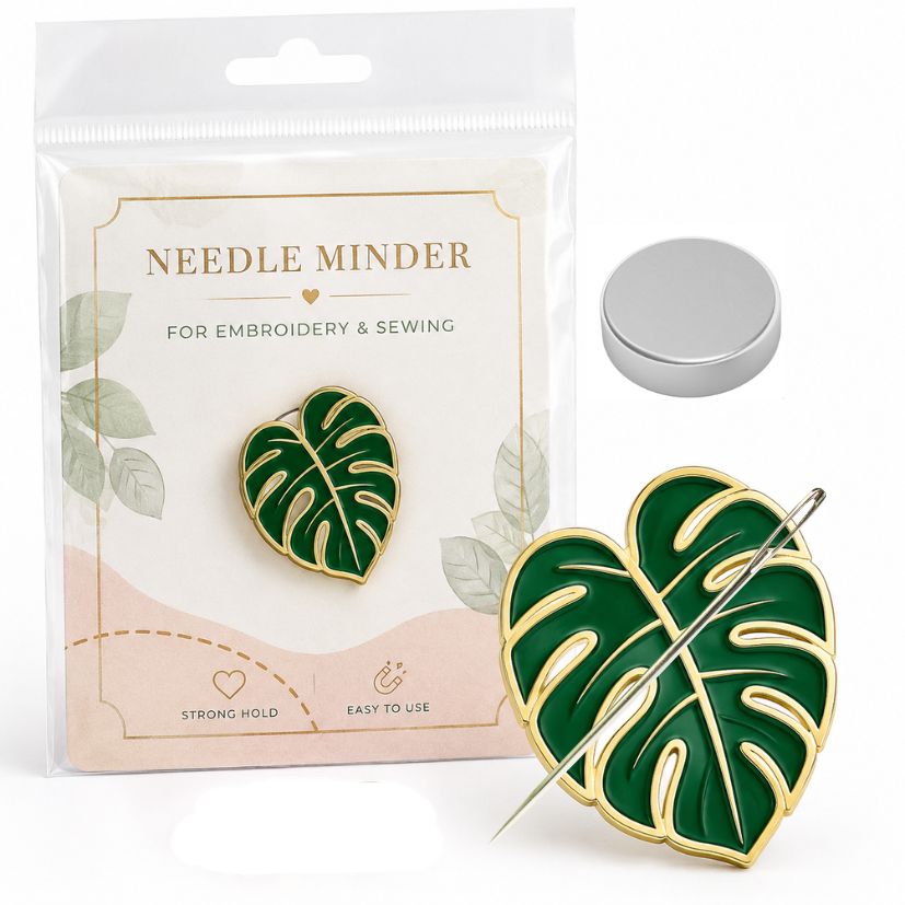Green monstera leaf enamel needle minder in custom card packaging with strong backing magnet for retail supply.